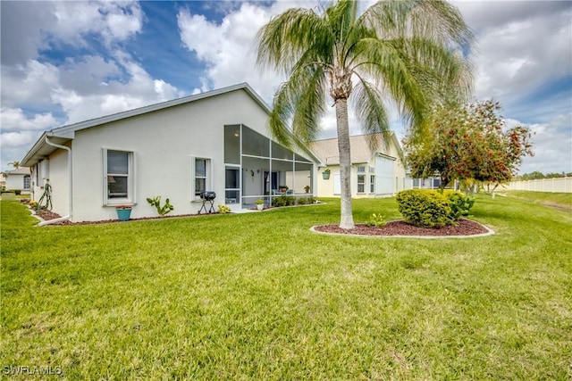 rear view of property with a yard and stucco siding