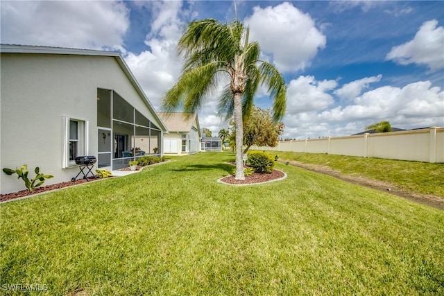 view of yard with a sunroom and fence