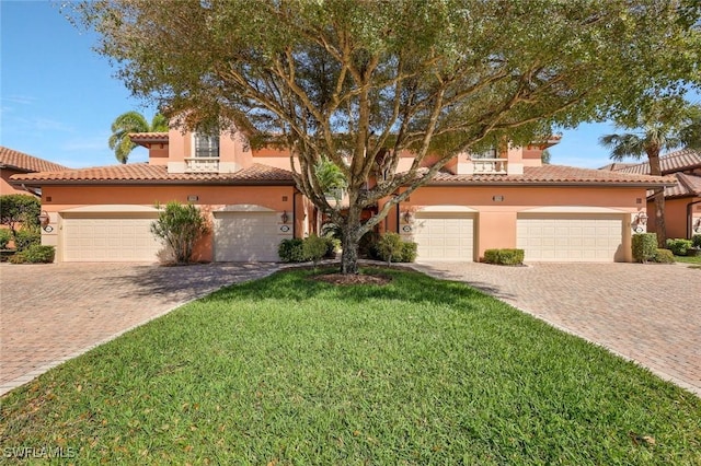 view of front of property with stucco siding, a tile roof, and decorative driveway