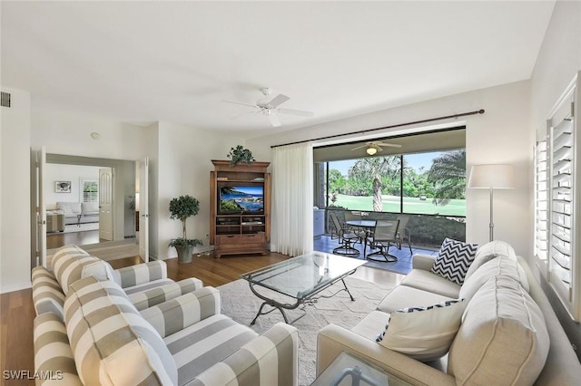 living room with visible vents, ceiling fan, and wood finished floors