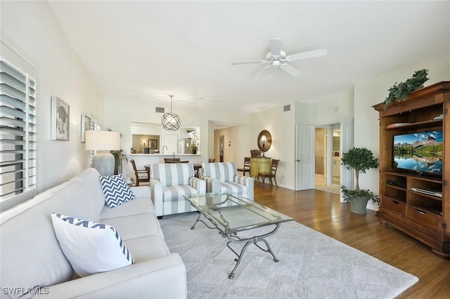living room with visible vents, a ceiling fan, and wood finished floors