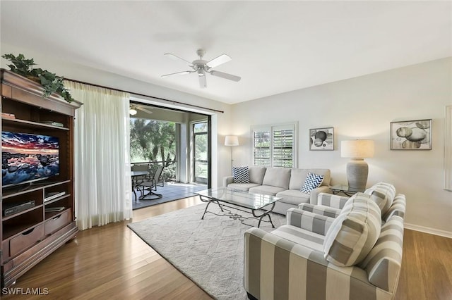 living room with wood finished floors, baseboards, and ceiling fan