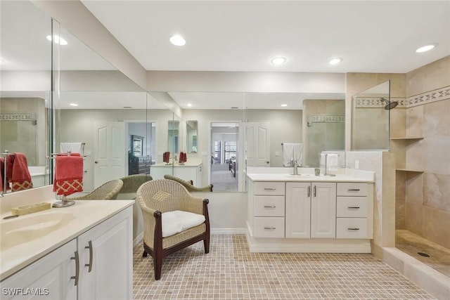 full bath featuring a sink, two vanities, recessed lighting, and walk in shower