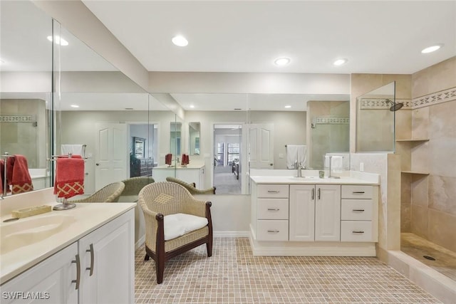 bathroom with a sink, walk in shower, recessed lighting, and two vanities
