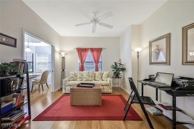 living room with plenty of natural light, baseboards, ceiling fan, and wood finished floors
