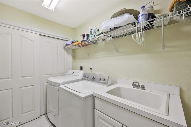 clothes washing area with a sink, independent washer and dryer, laundry area, and light tile patterned floors