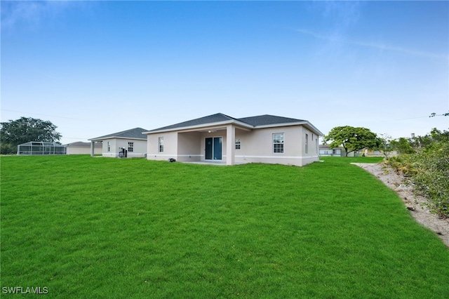 3109 11th St W, Lehigh Acres, FL 33971 - back of property with a lawn and stucco siding