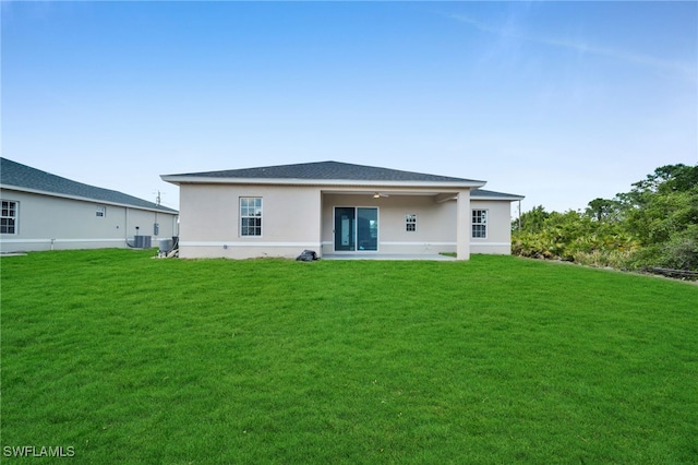 3109 11th St W, Lehigh Acres, FL 33971 - rear view of property featuring ceiling fan, a lawn, cooling unit, a patio, and stucco siding