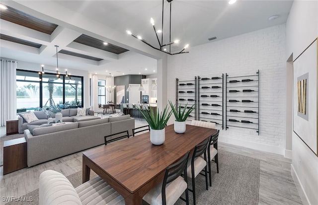 dining space featuring brick wall, coffered ceiling, baseboards, beamed ceiling, and an inviting chandelier