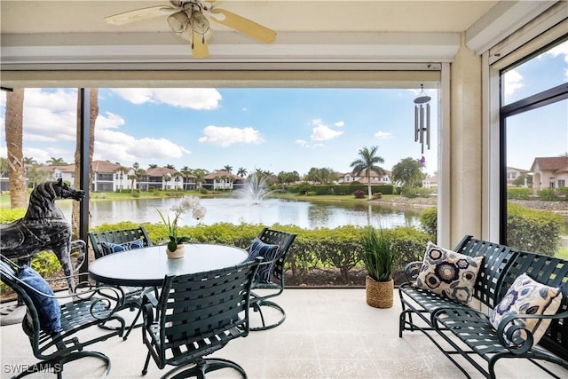 sunroom with a water view and ceiling fan