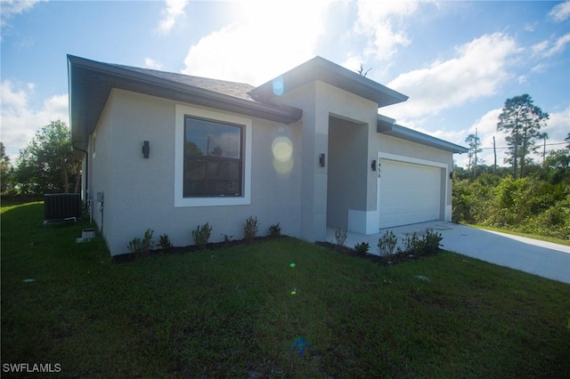 view of front facade featuring central AC unit, a garage, concrete driveway, stucco siding, and a front yard