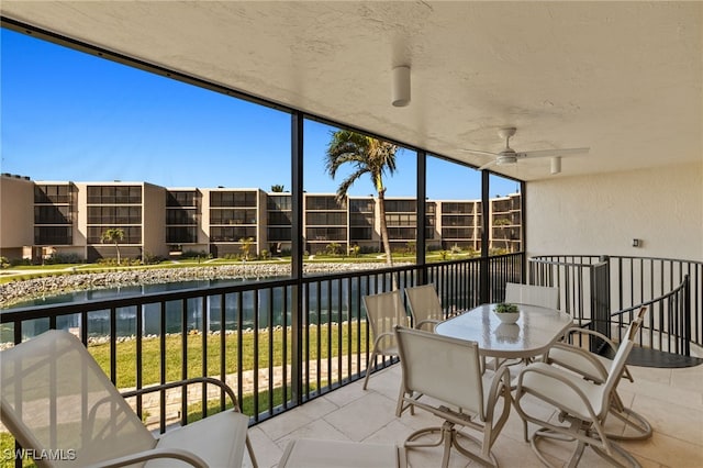 balcony with a water view and a ceiling fan