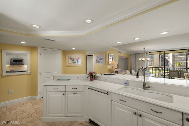 kitchen with ornamental molding, a sink, stainless steel microwave, recessed lighting, and a raised ceiling