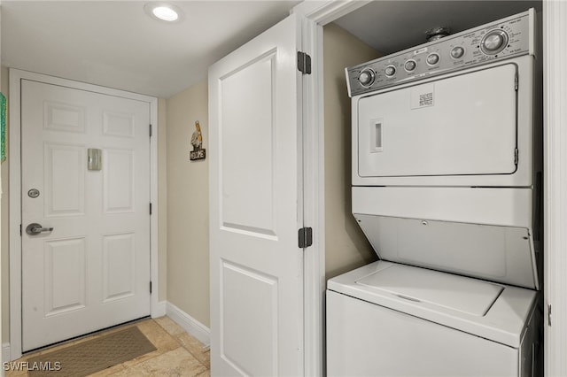 laundry room with laundry area, baseboards, and stacked washer and clothes dryer