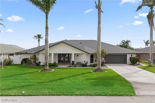 view of front facade with a garage, driveway, a front lawn, and stucco siding