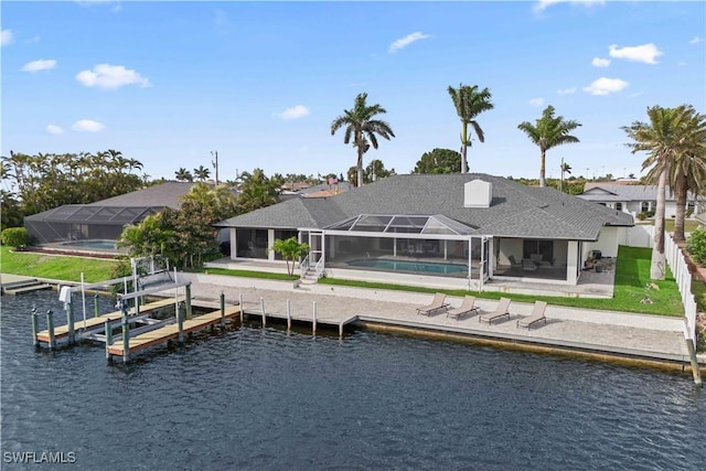 back of house with a water view, glass enclosure, a patio area, a fenced backyard, and an outdoor pool