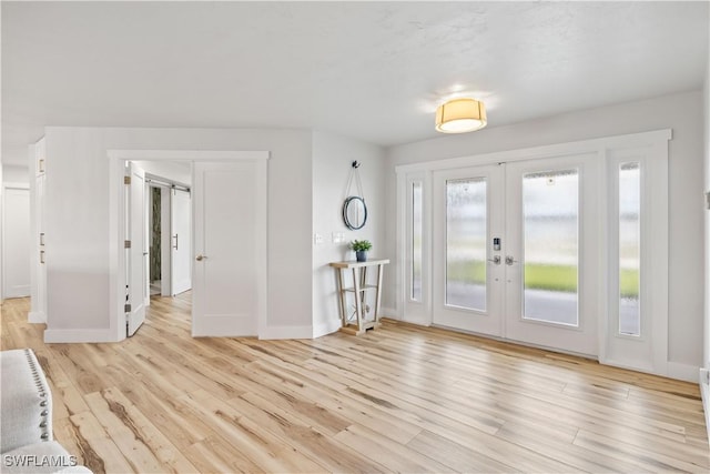 entryway with french doors, wood finished floors, and baseboards