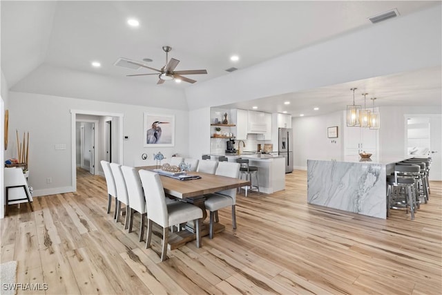 dining space featuring recessed lighting, lofted ceiling, visible vents, light wood-style floors, and baseboards