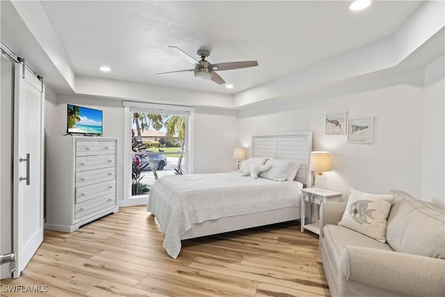 bedroom featuring light wood-style floors, a barn door, access to outside, and recessed lighting