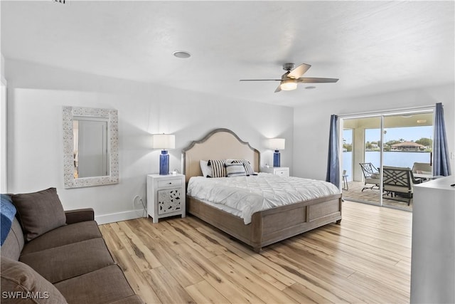 bedroom with light wood finished floors, a water view, ceiling fan, access to outside, and baseboards