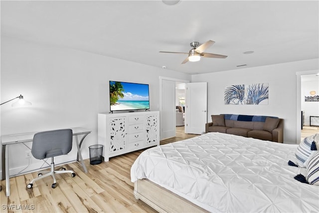 bedroom featuring a ceiling fan, visible vents, and wood finished floors