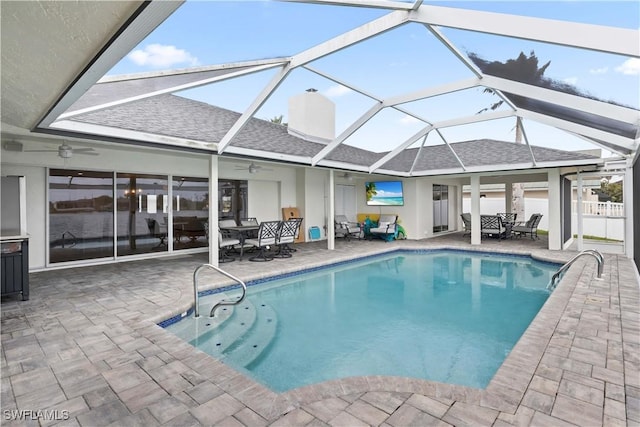 pool with ceiling fan, a patio, outdoor dining space, and glass enclosure