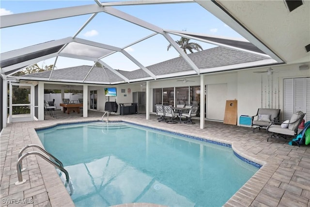 pool featuring outdoor dining area, outdoor lounge area, a ceiling fan, glass enclosure, and a patio area