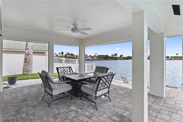 sunroom / solarium featuring a healthy amount of sunlight, a water view, and ceiling fan