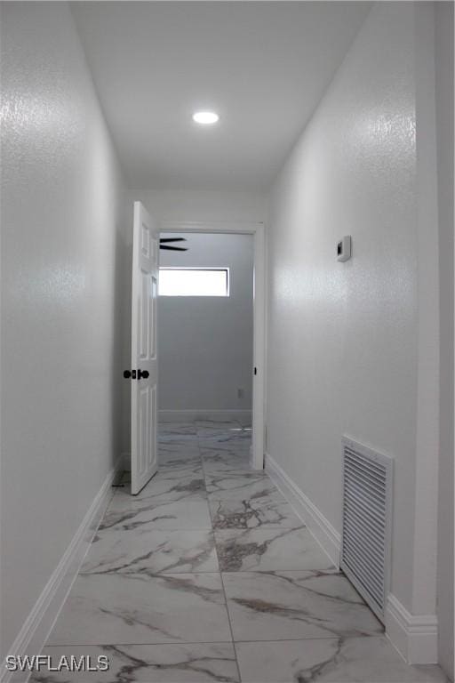 corridor featuring visible vents, baseboards, and marble finish floor