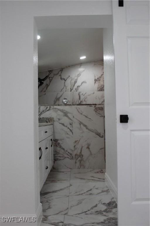 full bath with vanity, marble finish floor, and a marble finish shower