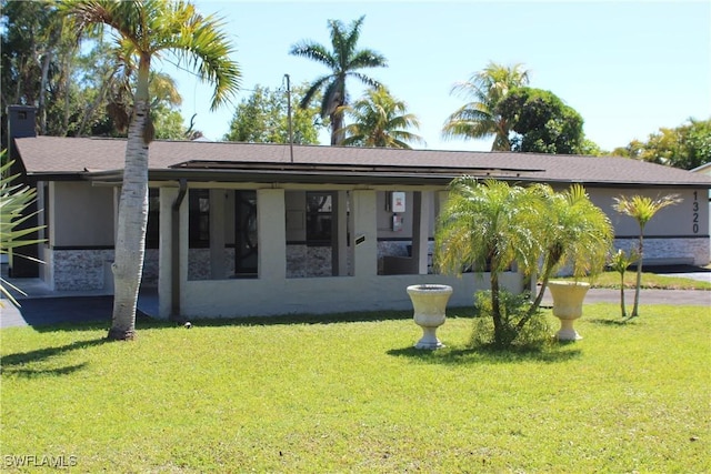 view of front of house with stucco siding and a front yard