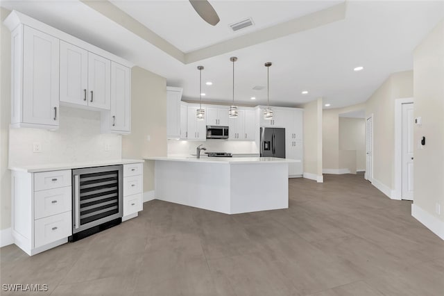 kitchen with beverage cooler, a peninsula, visible vents, white cabinetry, and appliances with stainless steel finishes