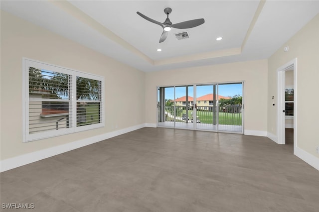 spare room featuring recessed lighting, a raised ceiling, visible vents, and baseboards