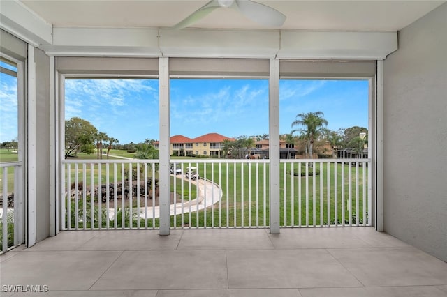 unfurnished sunroom featuring a ceiling fan