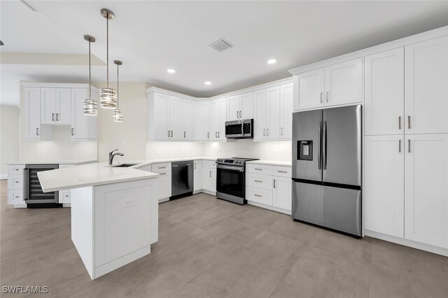 kitchen with beverage cooler, visible vents, appliances with stainless steel finishes, a peninsula, and a sink