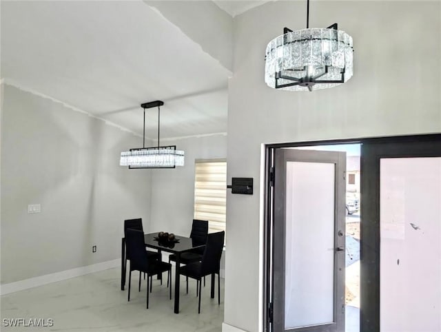 dining space featuring baseboards and a notable chandelier