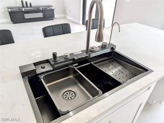 interior details featuring stone counters and a sink