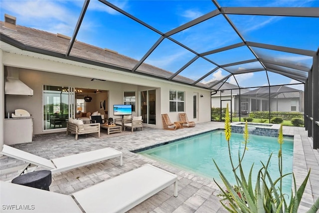 view of swimming pool with glass enclosure, area for grilling, a pool with connected hot tub, an outdoor living space, and a patio area