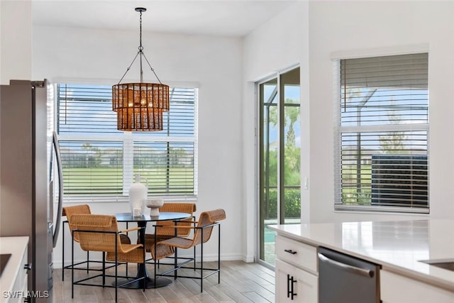 dining space with light wood-style floors, baseboards, and a chandelier