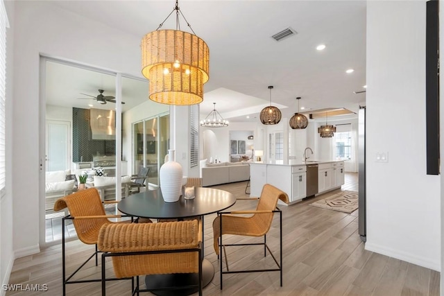 dining room with light wood-style flooring, recessed lighting, ceiling fan with notable chandelier, visible vents, and baseboards