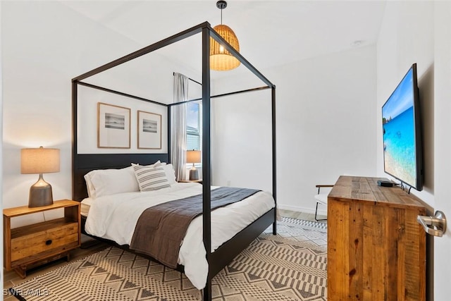 bedroom featuring baseboards and wood finished floors