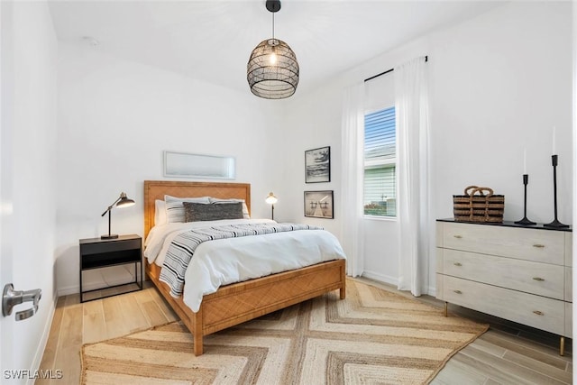 bedroom with light wood-type flooring and baseboards