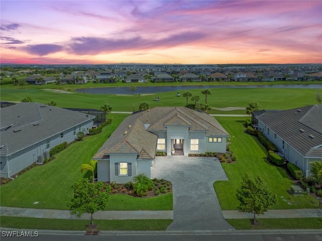 aerial view at dusk with a residential view and a water view