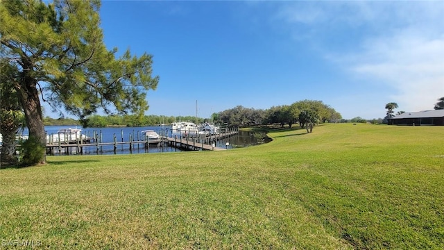 view of dock with a water view and a yard