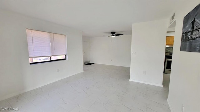 empty room featuring a ceiling fan, marble finish floor, visible vents, and baseboards