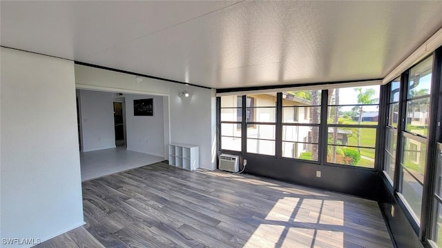 unfurnished sunroom with an AC wall unit