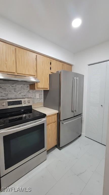 kitchen featuring marble finish floor, stainless steel appliances, light countertops, backsplash, and under cabinet range hood