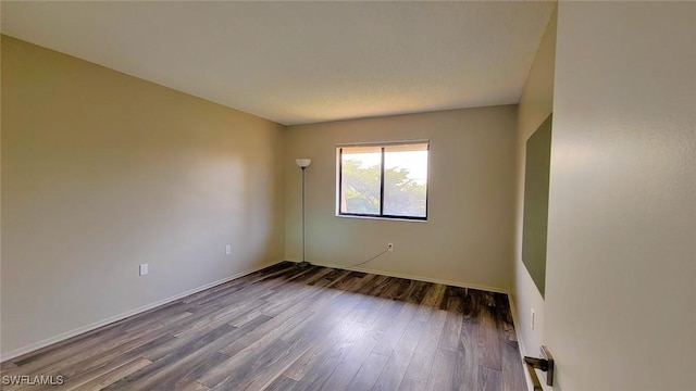 empty room featuring baseboards and wood finished floors