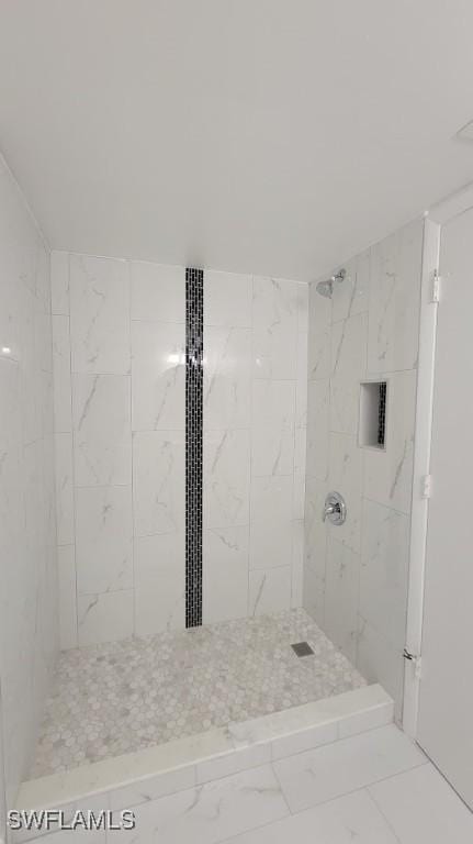 full bath with marble finish floor and tiled shower