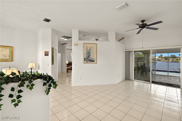 empty room with a water view, visible vents, and light tile patterned flooring